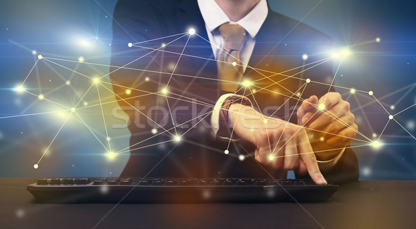 Man typing with connection graphics around Stock photo © ra2studio