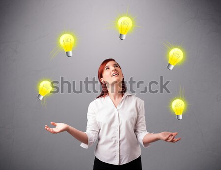 young lady sitting and juggling with light bulbs Stock photo © ra2studio