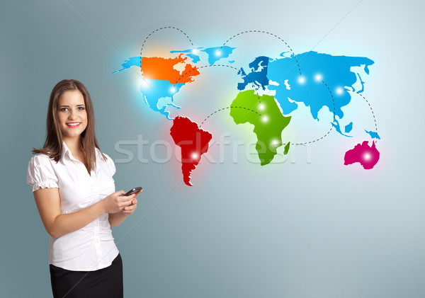 Young woman holding a phone and presenting colorful world map Stock photo © ra2studio