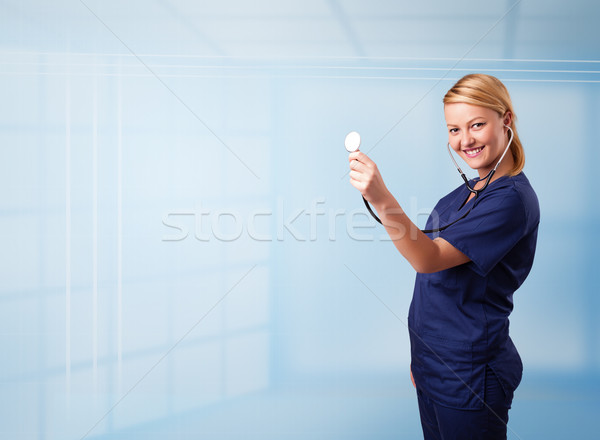 Pretty young nurse in hospital listening to empty copy space with sthetoscope Stock photo © ra2studio