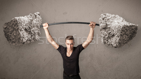 Stock photo: muscular man lifting large rock stone weights