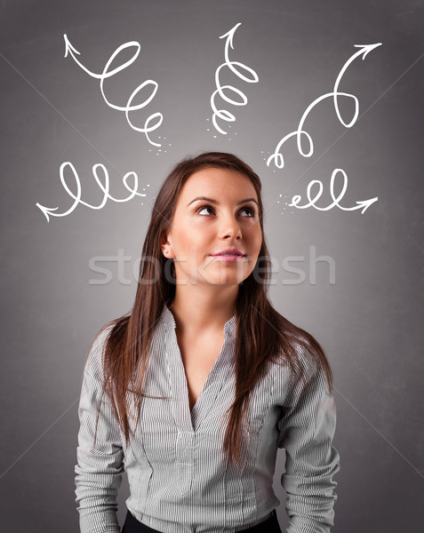 Stock photo: Young woman thinking with arrows overhead