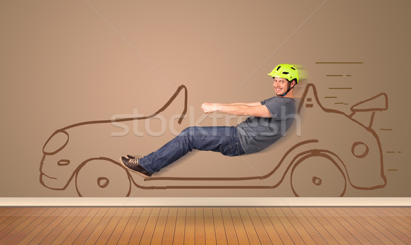 Happy man driving an hand drawn car on the wall Stock photo © ra2studio