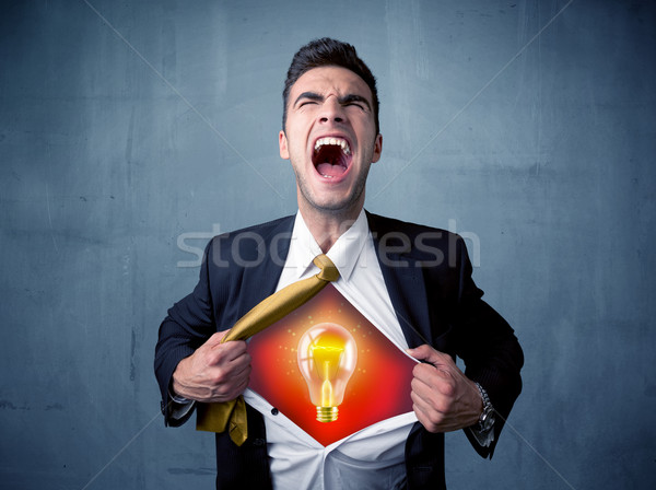 Businessman ripping off shirt and idea light bulb appears  Stock photo © ra2studio