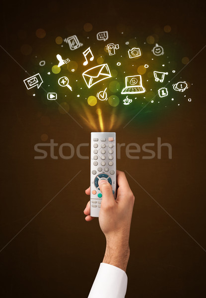 Hand with remote control and social media icons Stock photo © ra2studio