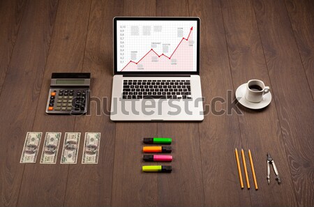 Computer desk with laptop and red arrow chart in screen Stock photo © ra2studio