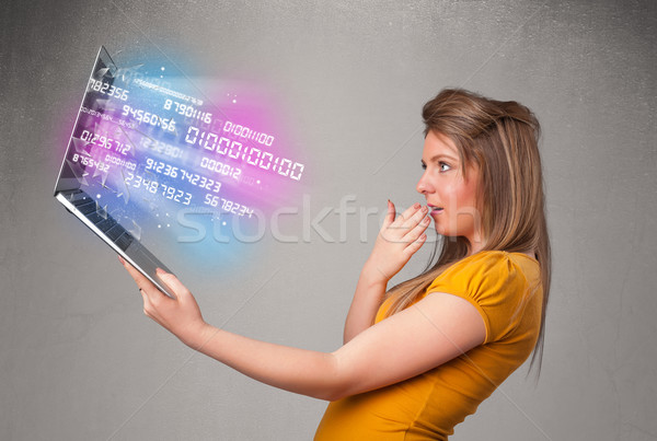 Stock photo: Casual woman holding laptop with exploding data and numers