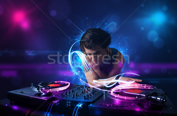 Disc jockey playing music with electro light effects and lights Stock photo © ra2studio