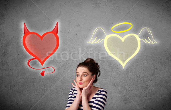 Woman standing between the angel and devil hearts Stock photo © ra2studio