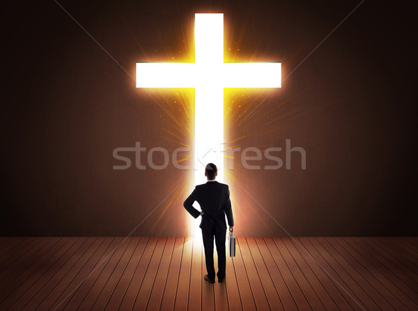 Stock photo: Man looking at bright cross sign 