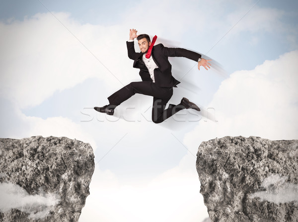 Funny business man jumping over rocks with gap Stock photo © ra2studio