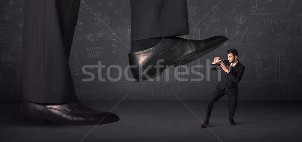 Huge leg stepping on a tiny businnessman concept Stock photo © ra2studio
