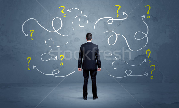 Unsure businessman with question marks Stock photo © ra2studio