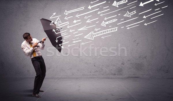 Business man standing with umbrella and drawn arrows hitting him Stock photo © ra2studio