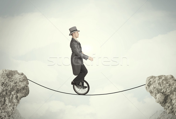 Bátor üzletember lovaglás bicikli sziklák üzletember Stock fotó © ra2studio