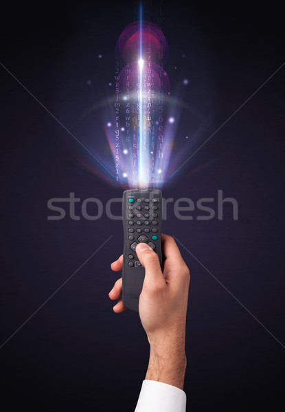 Hand with remote control and shining numbers Stock photo © ra2studio