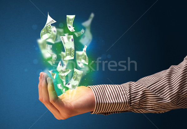 Stock photo: Glowing money in the hand of a businessman
