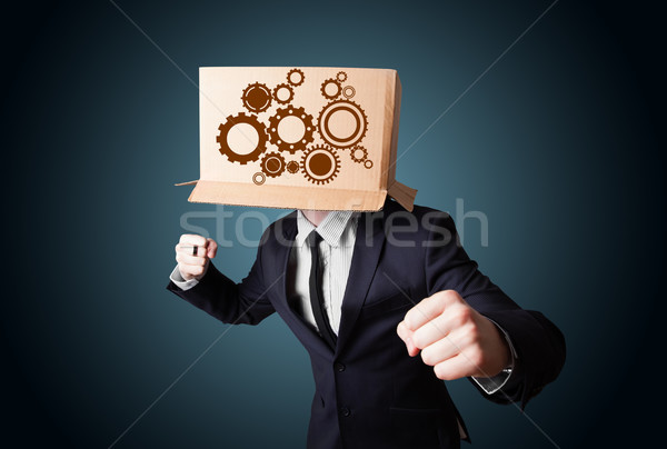 Businessman gesturing with a cardboard box on his head with spur Stock photo © ra2studio