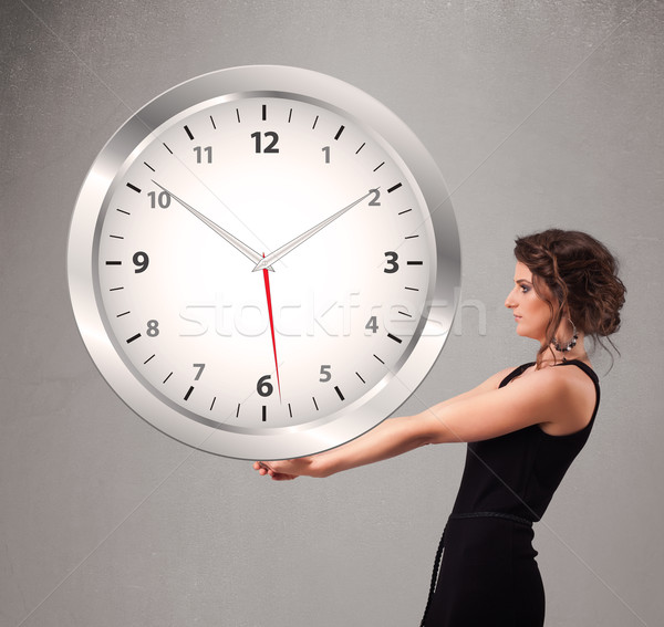 Attractive lady holding a huge clock Stock photo © ra2studio