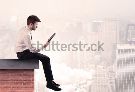 Office worker sitting on rooftop in city Stock photo © ra2studio