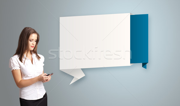 pretty young woman holding a phone and presenting modern origami copy space Stock photo © ra2studio