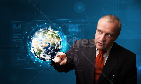 Businessman touching high-tech 3d earth panel Stock photo © ra2studio