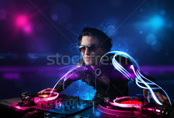 Disc jockey playing music with electro light effects and lights Stock photo © ra2studio