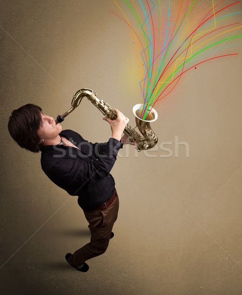 Attractive musician playing on saxophone while colorful abstract Stock photo © ra2studio