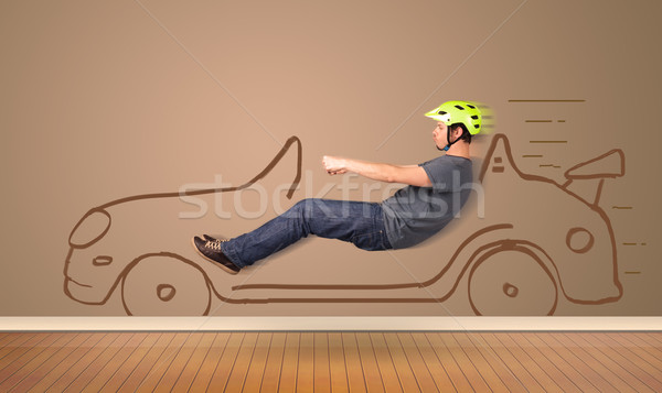 Happy man driving an hand drawn car on the wall Stock photo © ra2studio