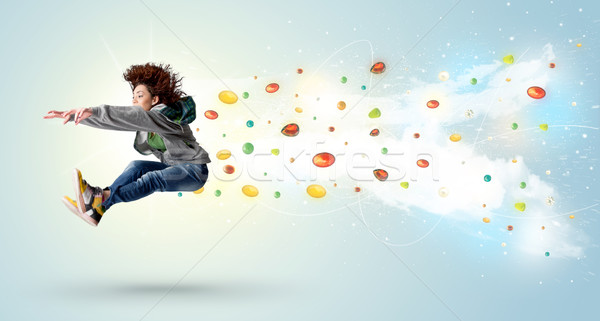 Stock photo: Beautiful woman jumping with colorful gems and crystals on the b