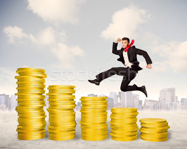 Bem sucedido homem de negócios saltando para cima moeda de ouro dinheiro Foto stock © ra2studio