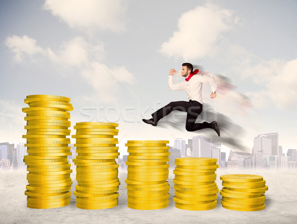 Bem sucedido homem de negócios saltando para cima moeda de ouro dinheiro Foto stock © ra2studio