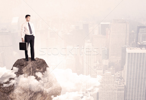 Happy businessman standing on stone top Stock photo © ra2studio