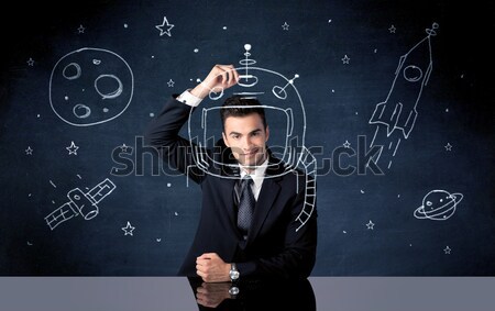 Sales person drawing helmet and space rocket Stock photo © ra2studio