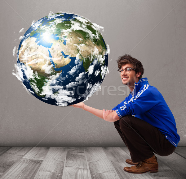 Good-looking man holding 3d planet earth Stock photo © ra2studio