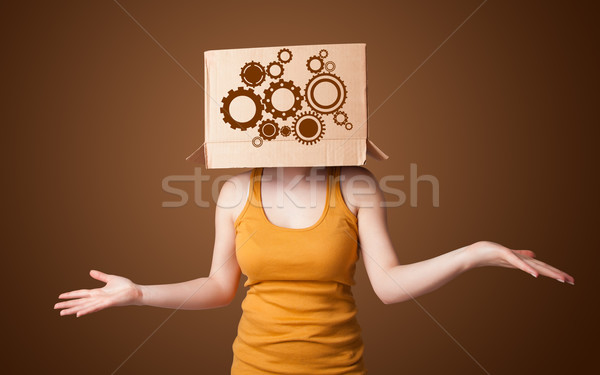 Young woman gesturing with a cardboard box on his head with spur Stock photo © ra2studio