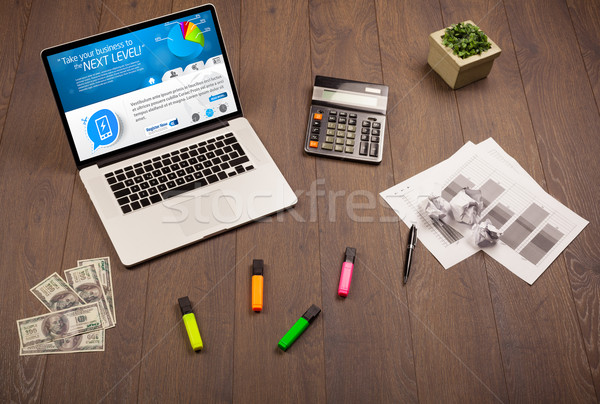 Laptop on office desk with business website on screen Stock photo © ra2studio