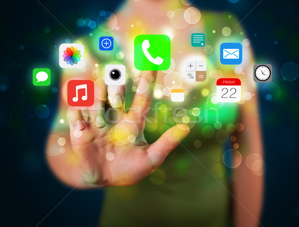 Young businesswoman pressing colorful mobile app icons with boke Stock photo © ra2studio