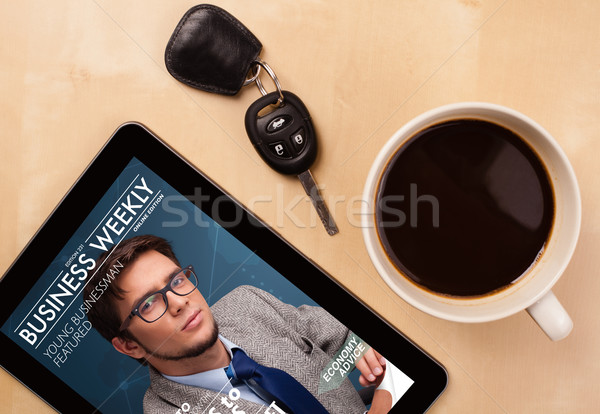 Workplace with tablet pc showing magazine cover and a cup of coffee on a wooden work table closeup Stock photo © ra2studio