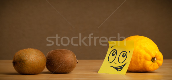 Lemon with post-it note looking at kiwis Stock photo © ra2studio