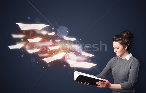 Young lady reading a book with flying sheets coming out of the b Stock photo © ra2studio