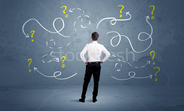 Unsure businessman with question marks Stock photo © ra2studio