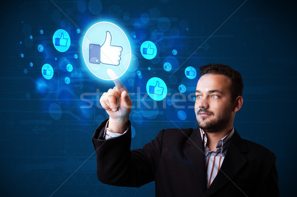 Handsome person pressing thumbs up button on modern social netwo Stock photo © ra2studio