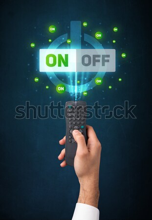 Hand with remote control and on-off signals Stock photo © ra2studio