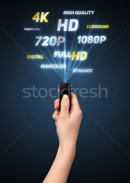 Stock photo: Hand with remote control and multimedia properties