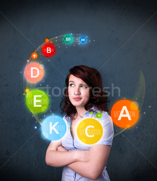 Young woman thinking with vitamins circulation around her head Stock photo © ra2studio