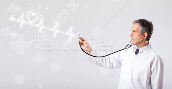 Doctor examinates heartbeat with abstract heart Stock photo © ra2studio