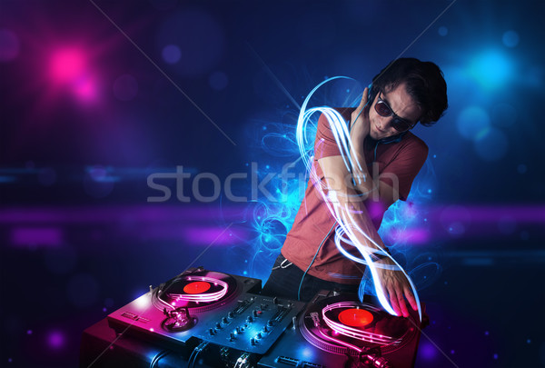 Disc jockey playing music with electro light effects and lights Stock photo © ra2studio