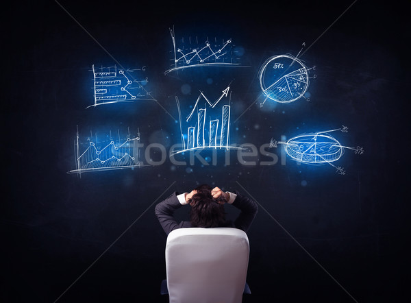 Stock photo: Businessman in chair looking at charts