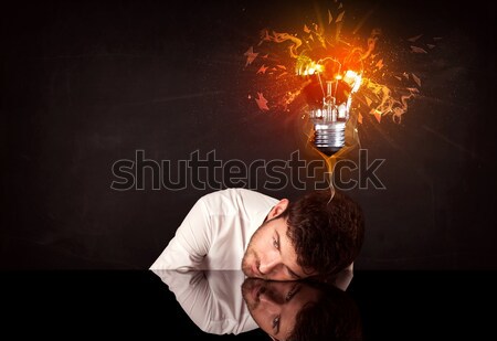 Businessman sitting under a blowing idea bulb Stock photo © ra2studio